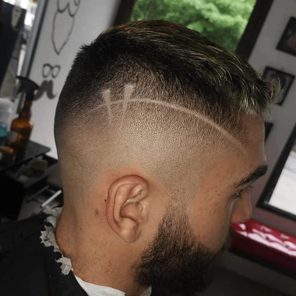 Fade with shaved design and shaped beard